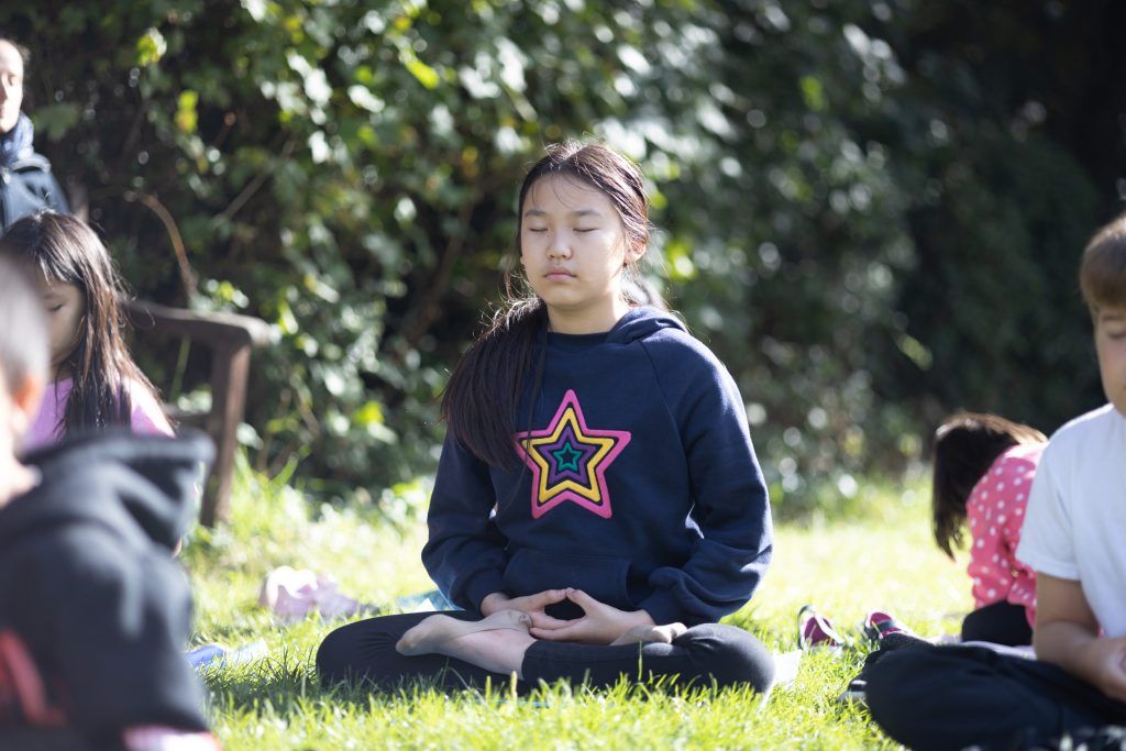 静坐 夏令营的女孩在草地上打坐